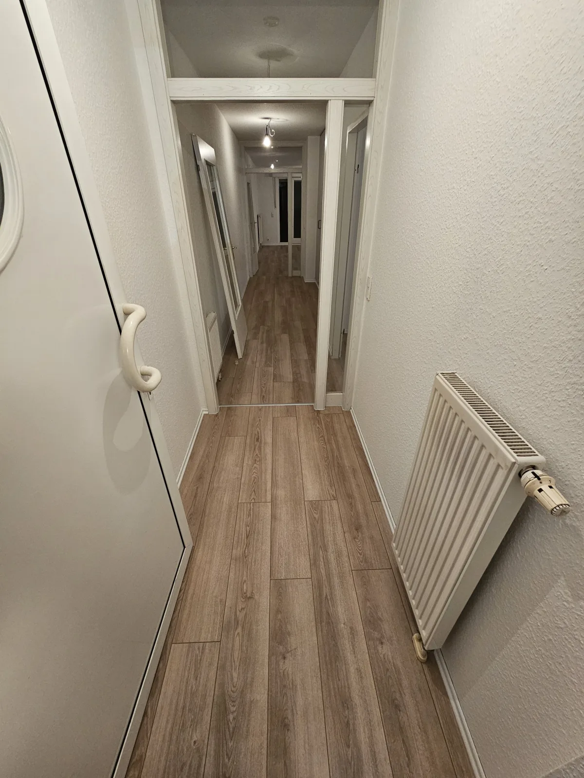 Derselbe Flur mit neu verlegtem Holzboden in Eichenoptik nach der Verlegung
