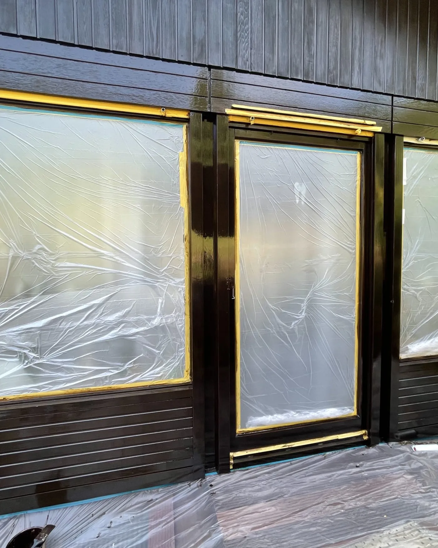 Frisch dunkel lackierte Holzfenster und Holzverkleidung mit glänzender Oberfläche