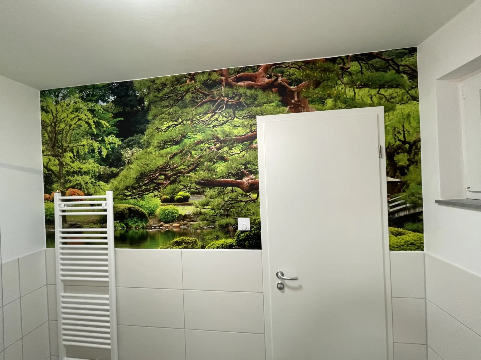 Dieselbe Wand mit tapezierter Fototapete eines japanischen Gartens nach den Tapezierarbeiten